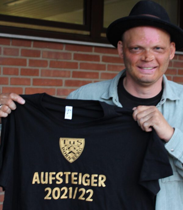 Thies Kambach, unser sportlicher Leiter , präsentiert das "Aufsteiger-T-Shirt"